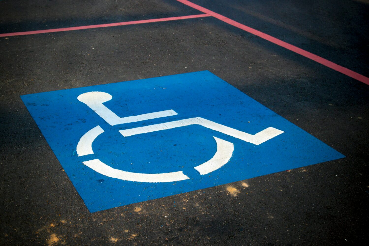 A blue parking space with a white wheelchair symbol indicating a designated spot for disabled individuals in Torrance, CA