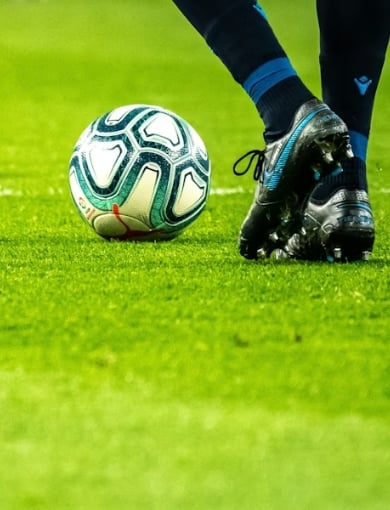 Player kicking soccer ball on field during game