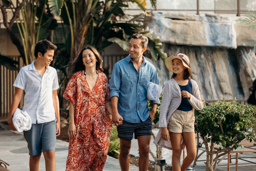 family of four walking near pool
