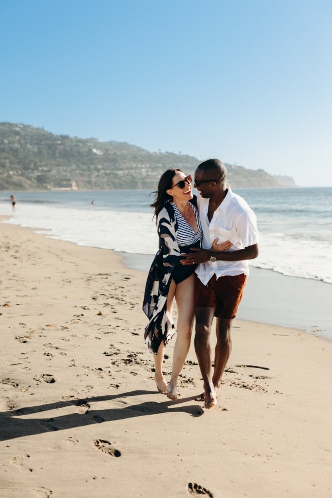 Couple embracing and laughing during a stroll on Torrance Beach