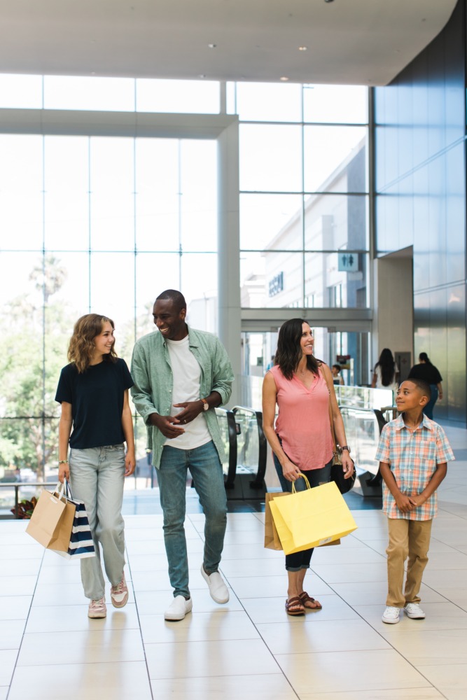 Family walking through and shopping Del Amo Fashion Center mall