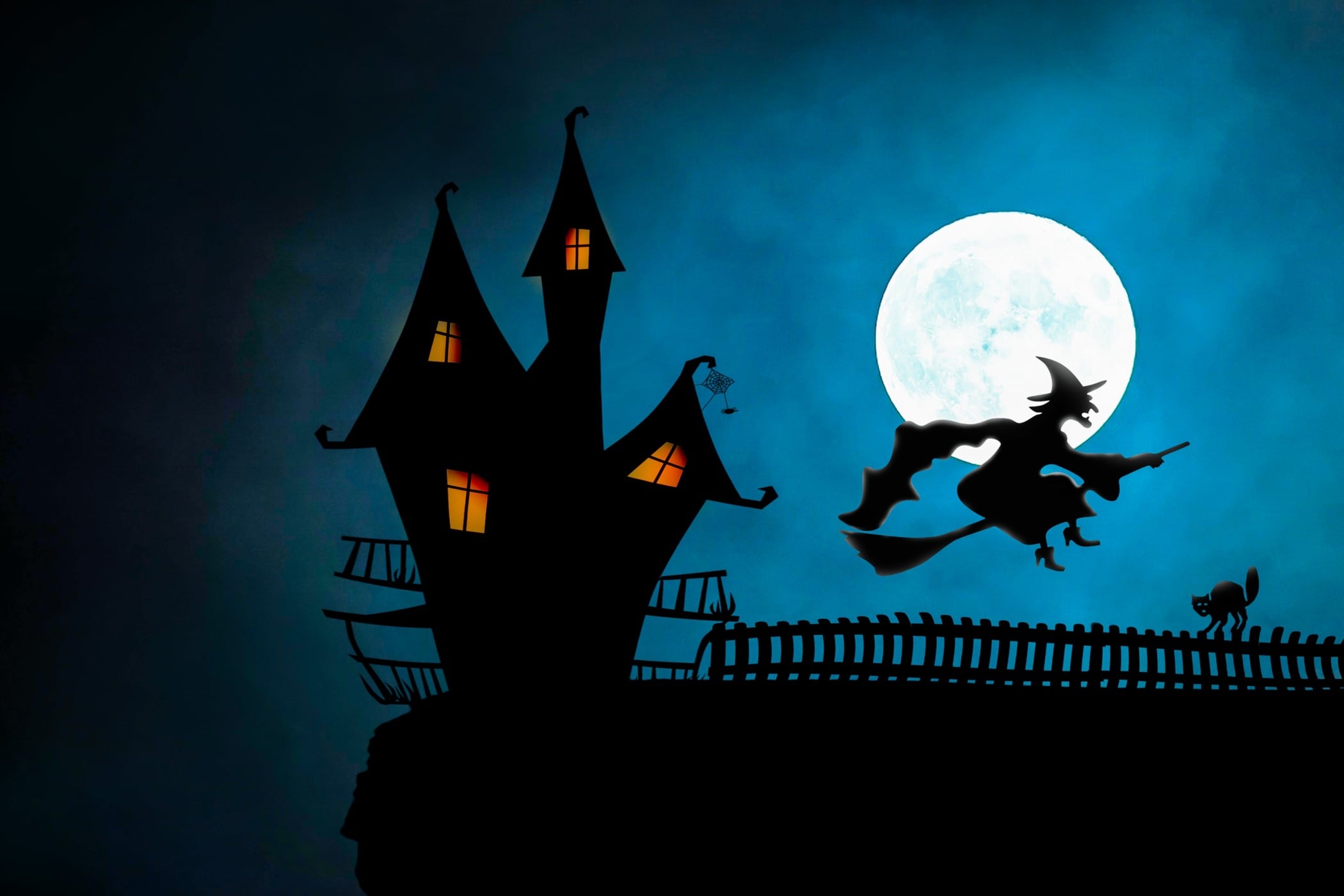 haunted house with witch flying over full moon